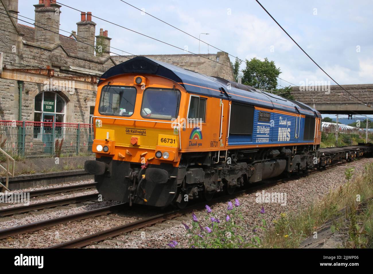 GBRf diesel-electric 66731 in special livery and named Capt Tom Moore A True British Inspiration, with legend Thank you NHS. Carnforth 27 July 2022. Stock Photo