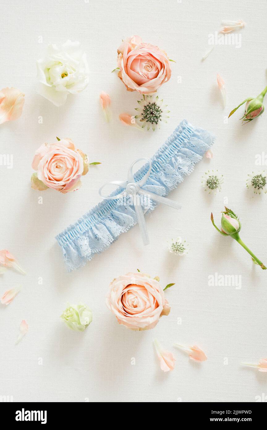 A vertical flat lay of a blue wedding garter and roses Stock Photo Alamy