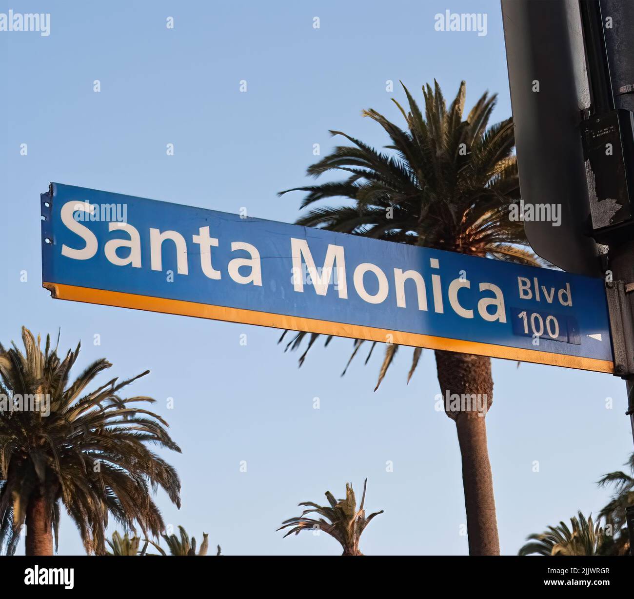 Santa Monica boulevard road sign against a bright blue sky and palm