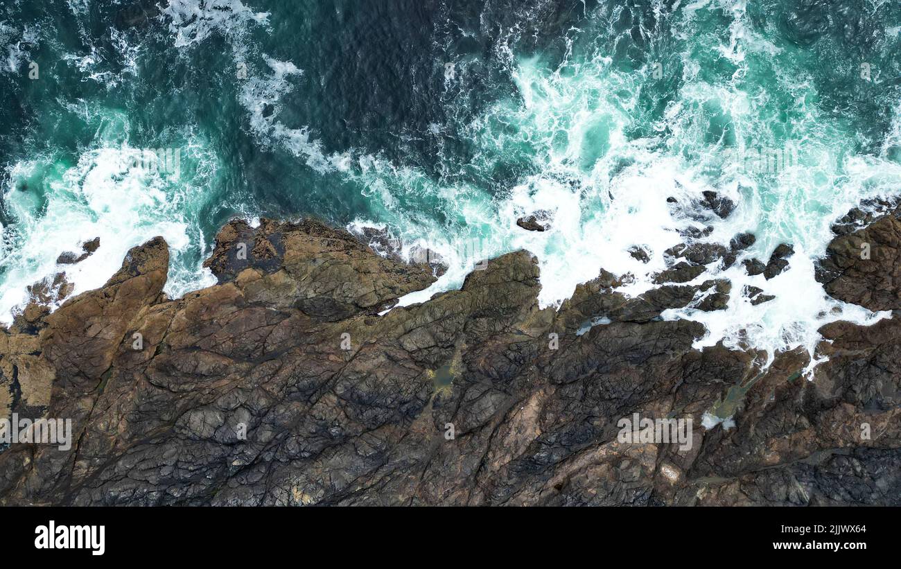 The top view of ocean waves hitting the rocky shore Stock Photo - Alamy
