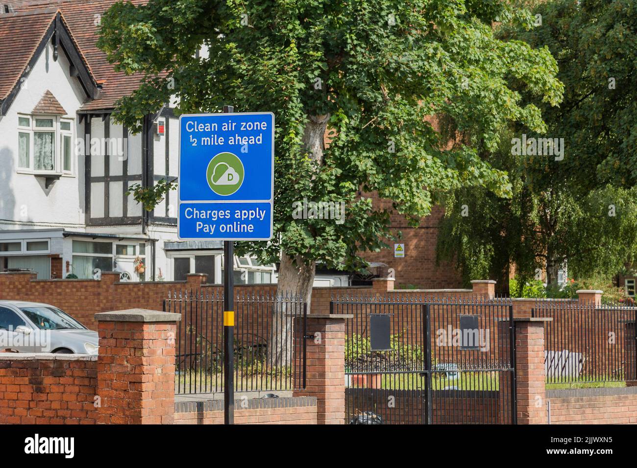 A road traffic sign informs motorists that they are approaching a clean air zone and charges may apply if they enter. Air quality, pollution concept. Stock Photo