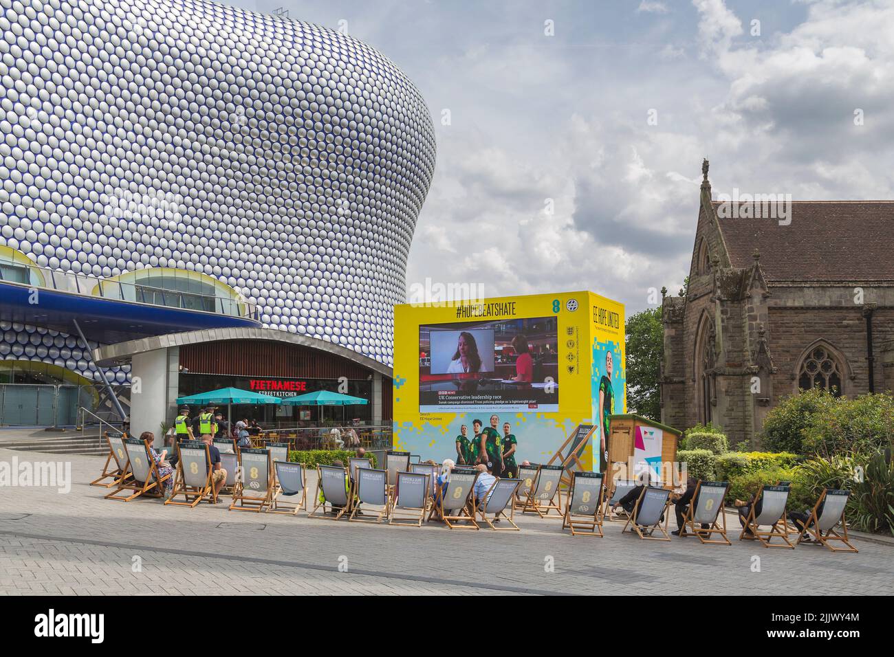 People watching a television screen sponsored by EE, for the Hope United campaign. The campaign aims to push back against misogyny and sexism. Stock Photo