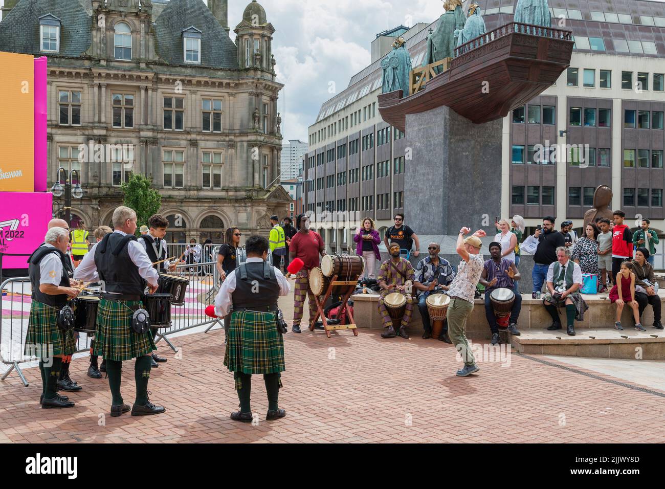 Birmingham Irish Pipes and Drums performing with Jamaican drummers in  Victoria square, to celebrate the 2022 Birmingham Commonwealth Games. Stock Photo