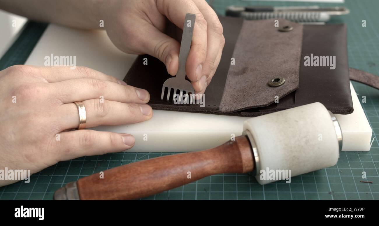 Punching holes in the leather with a hole punch with a hammer