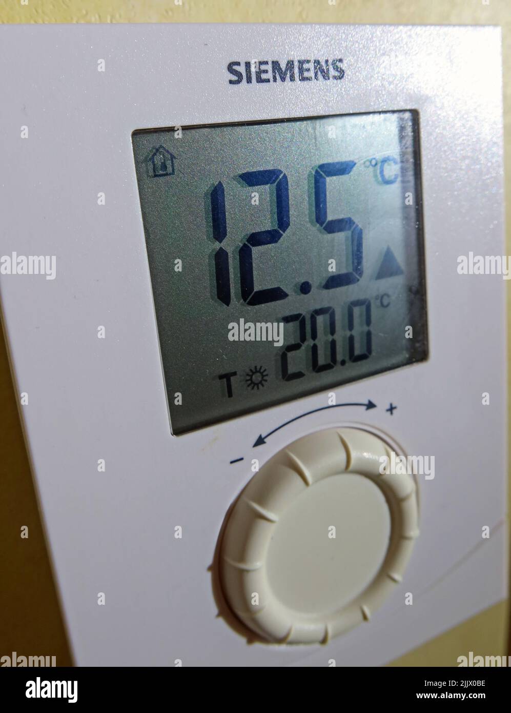Home heating thermostat in cold weather (12deg), with target temperature of 20dec. Challenges of being able to afford adequate heating Stock Photo