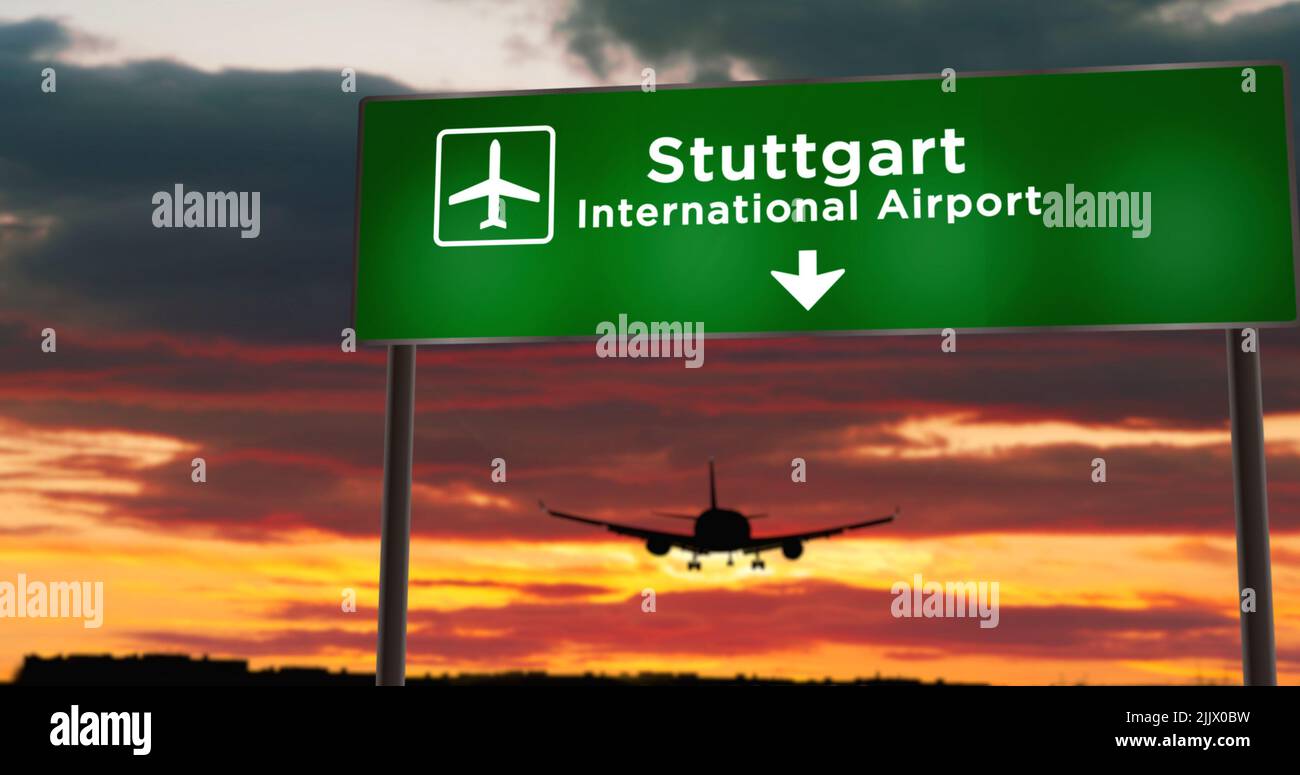Airplane silhouette landing in Stuttgart, Germany. City arrival with airport direction signboard and sunset in background. Trip and transportation con Stock Photo