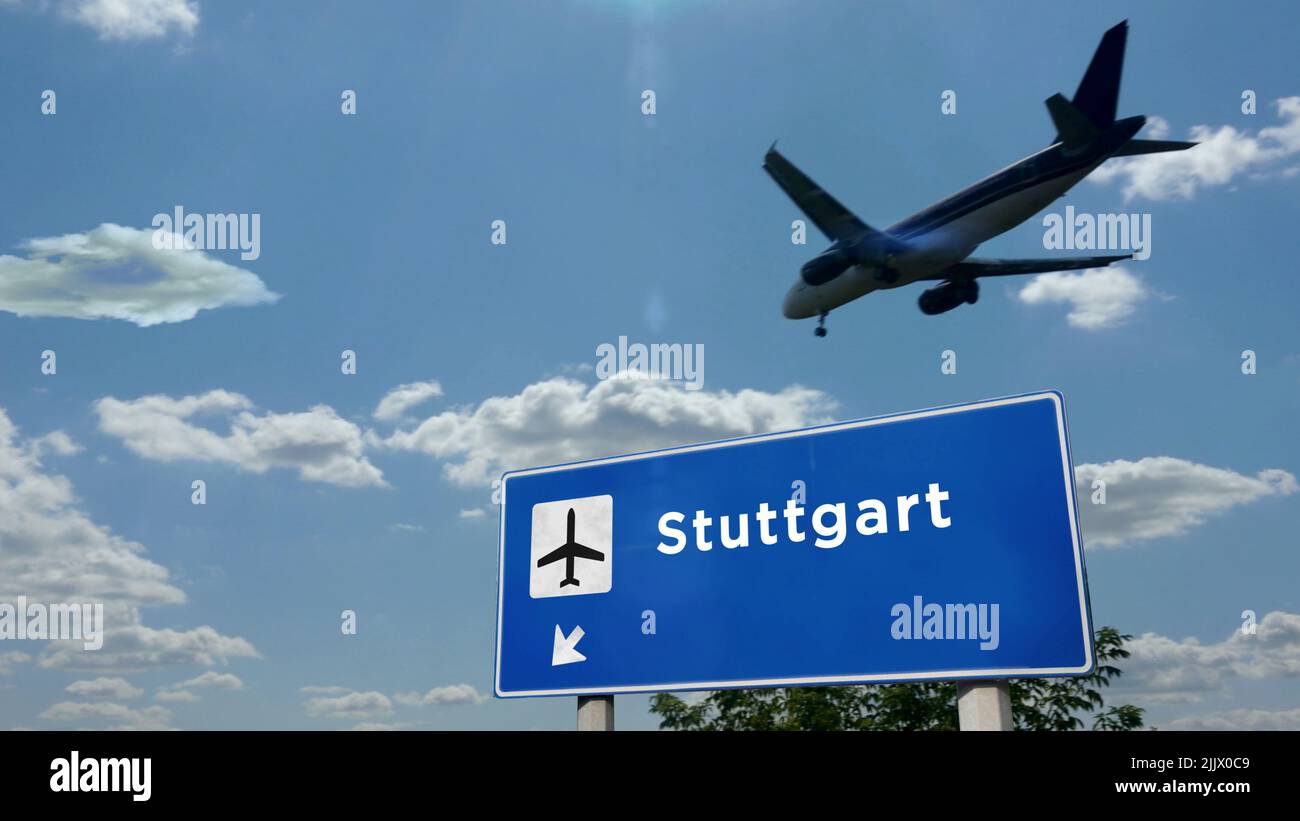 Airplane silhouette landing in Stuttgart, Germany. City arrival with international airport direction signboard and blue sky. Travel, trip and transpor Stock Photo