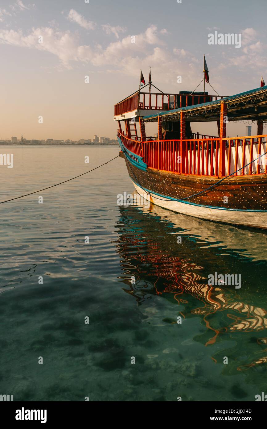 Traditional boat tied to pier with rope floating on rippling sea water
