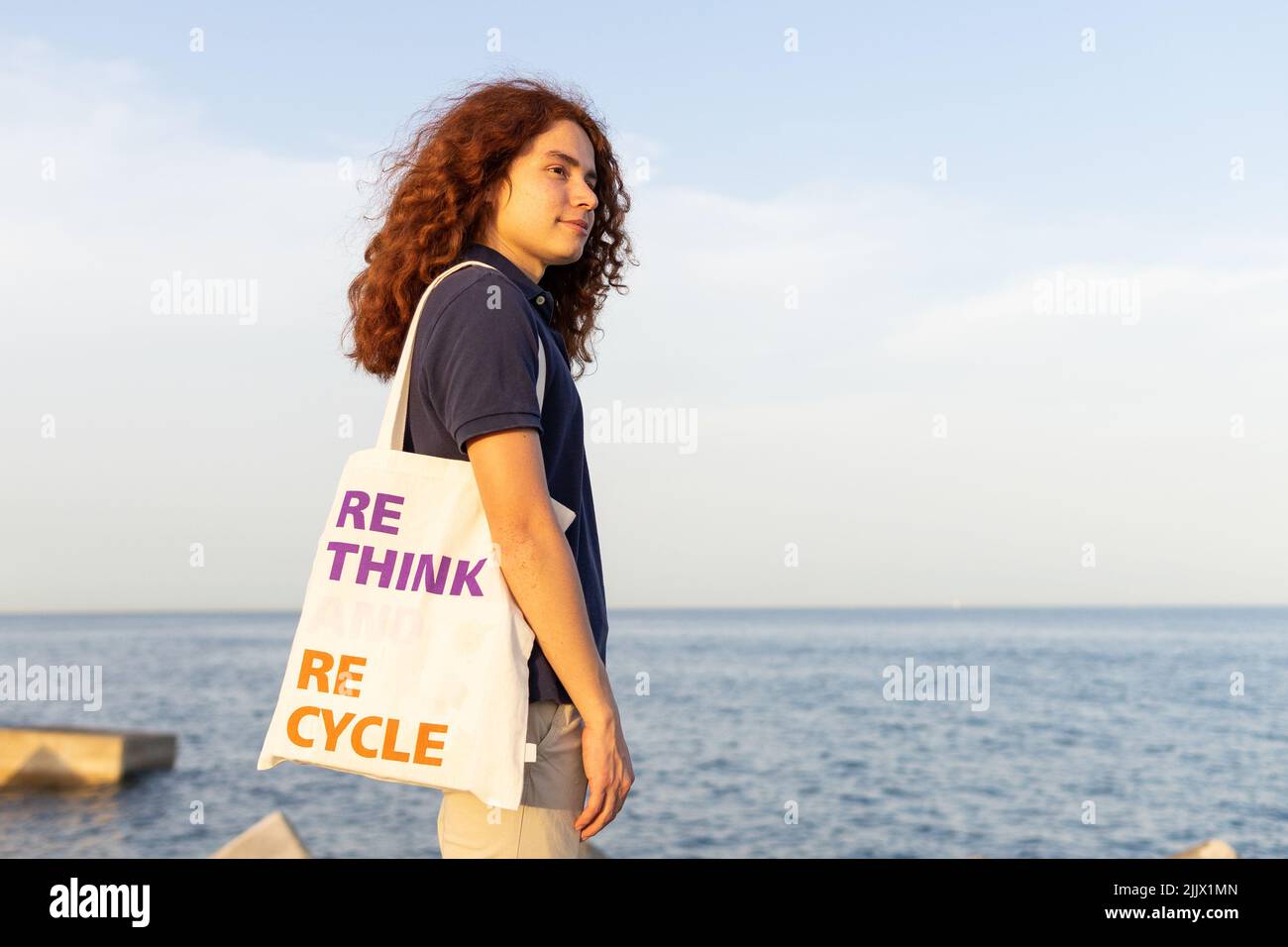 Side view of young Woman carrying shoulder bag with rethink and recycle