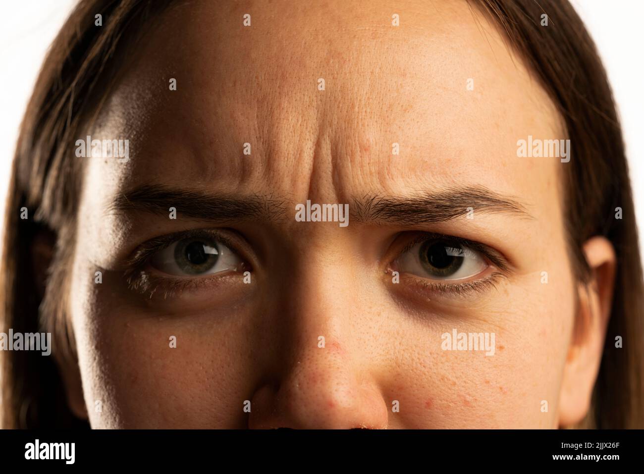 Closeup of young angry woman's wrinkles on her forehed Stock Photo