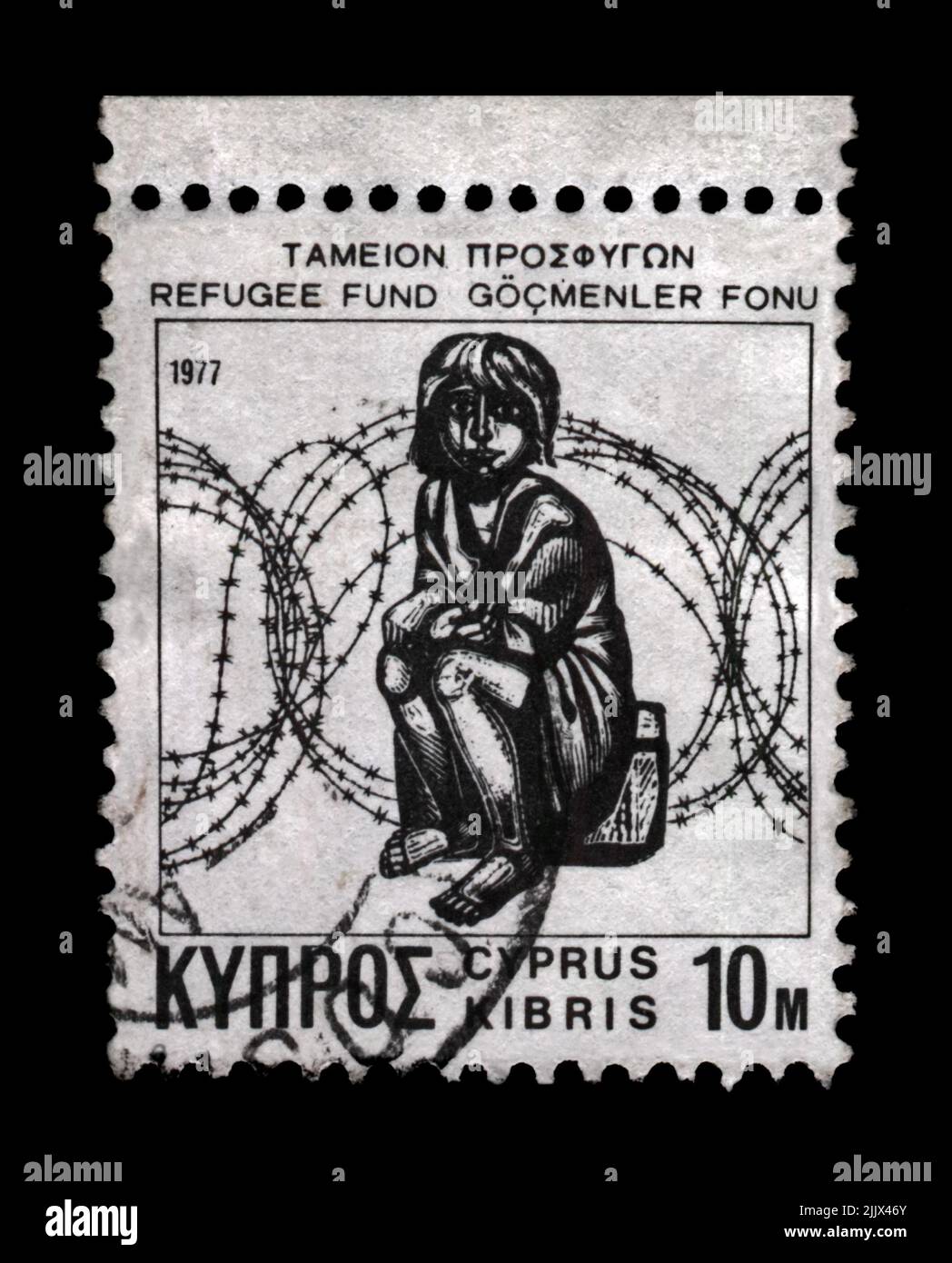 refugee child and barbed wire, circa 1977. canceled vintage postal stamp printed in Cyprus isolated on black background. Stock Photo