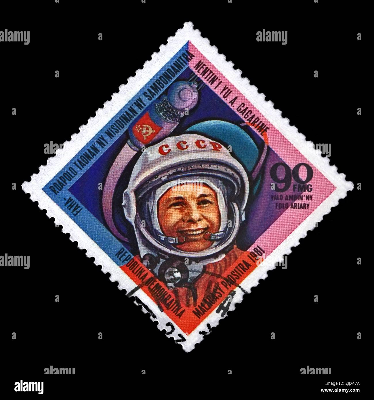 Yuri Gagagin, soviet astronaut, first human in the space, red soviet flag, circa 1981. vintage postal stamp printed in Madagascar (previously Malagasy Stock Photo