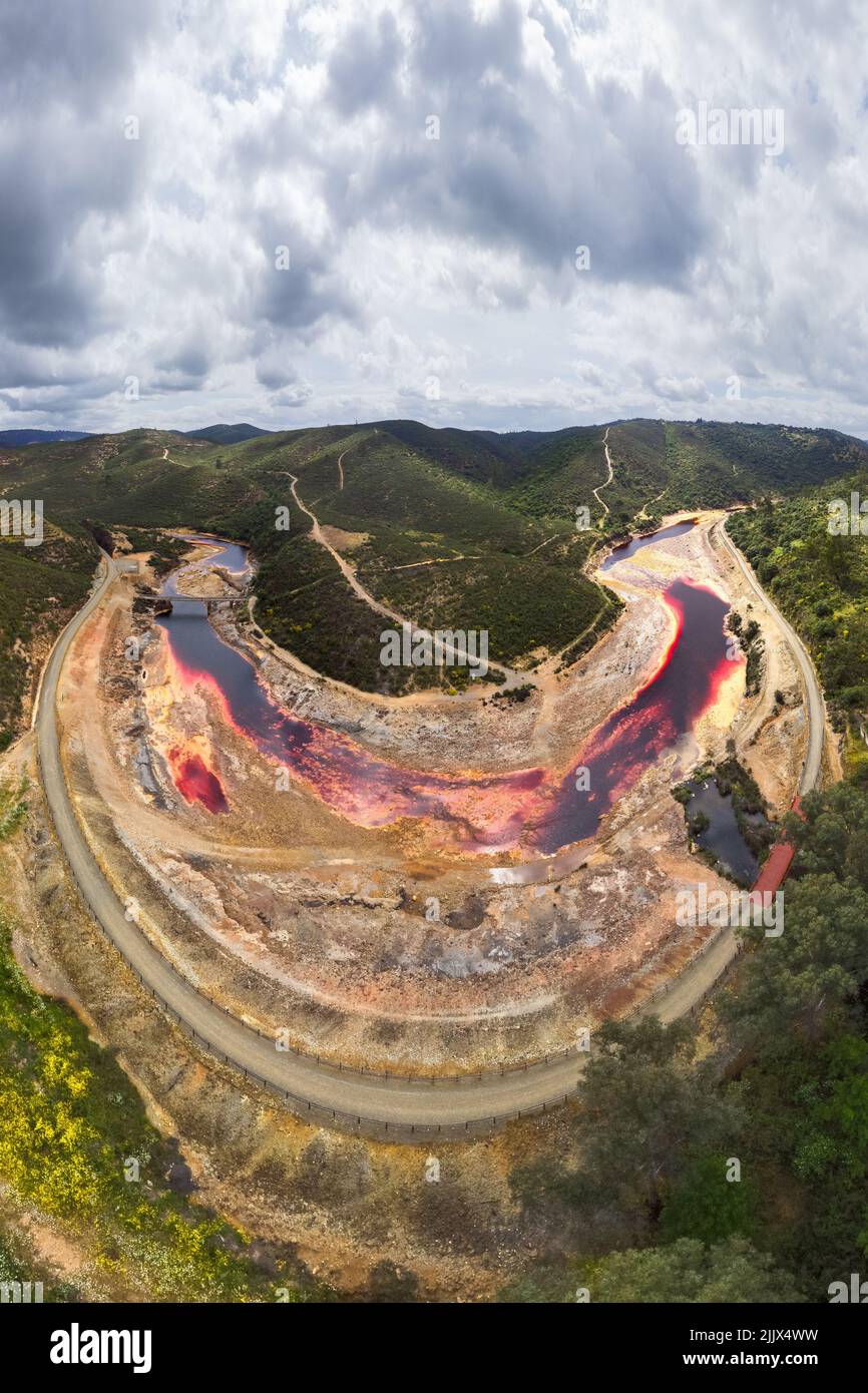 From above breathtaking scenery of curved river near forest cover in green trees in highlands in Minas de Riotinto in long exposure Stock Photo