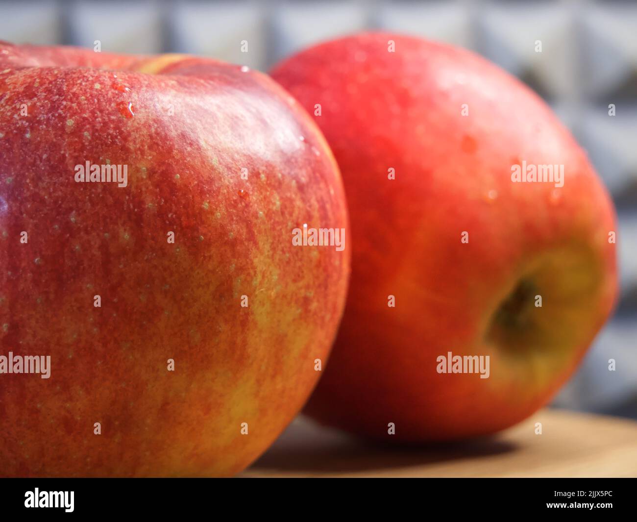 Two large red apples on a wooden surface. Ripe fruit macro. Gala apples