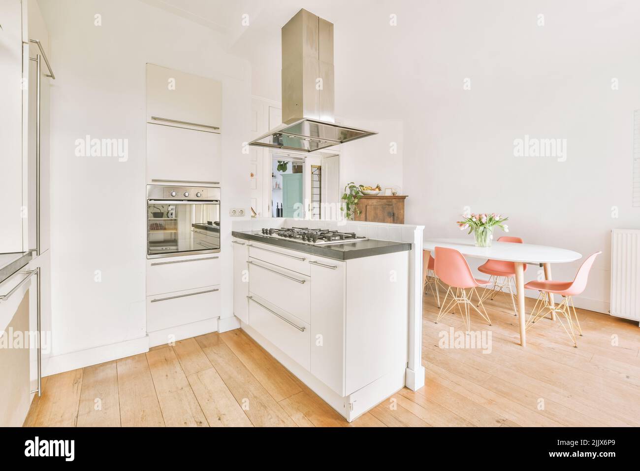 Dining table with chairs placed in contemporary spacious kitchen with
