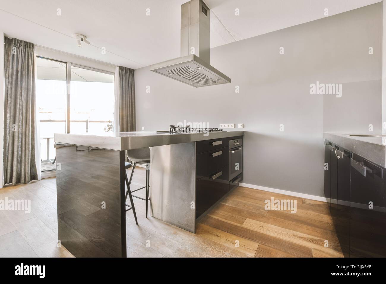 Interior of contemporary open plan kitchen with black counters and ...