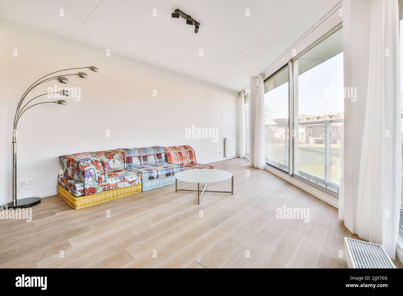 Interior of spacious refurbished living room with colorful couches
