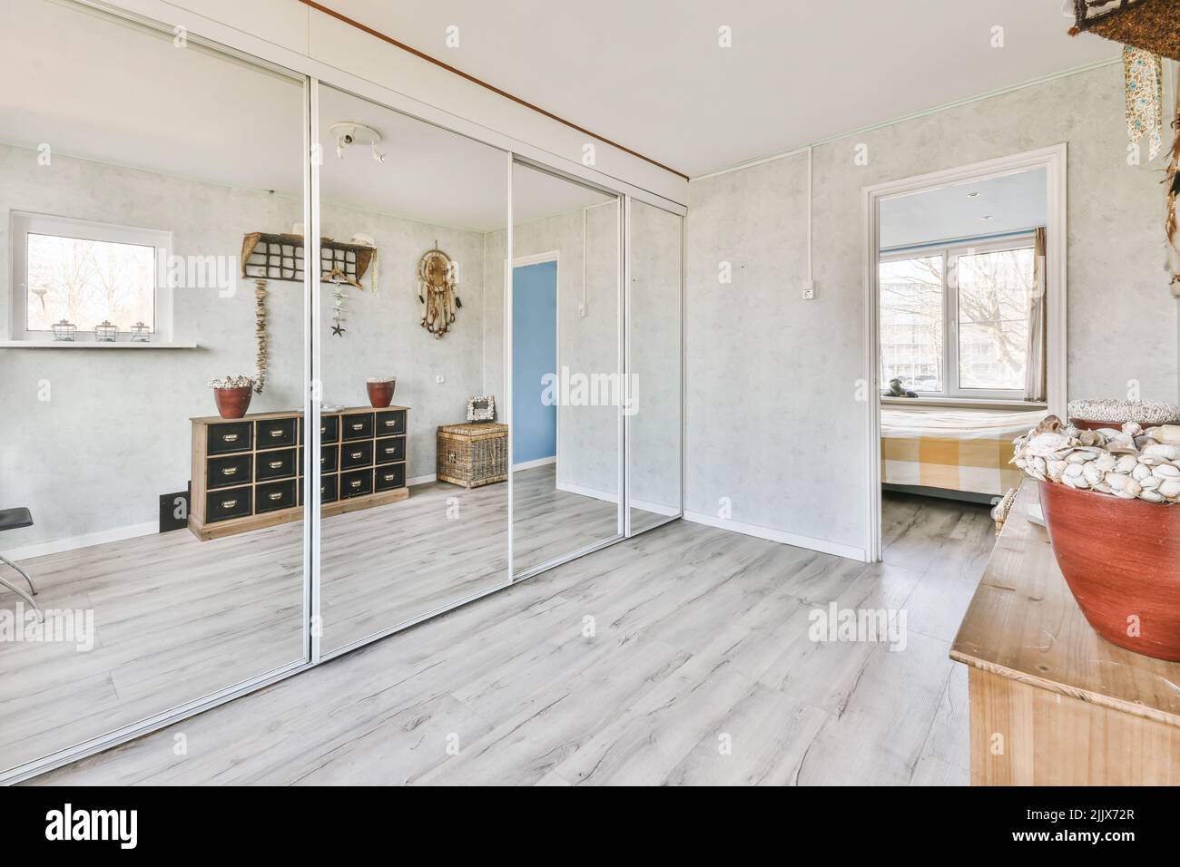 Spacious built in closet with mirror doors in apartment with wooden