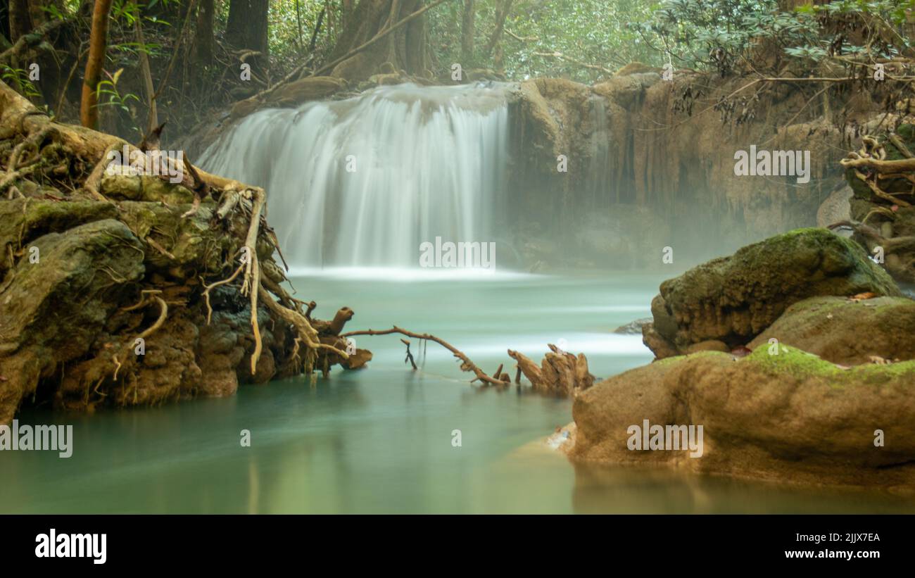 A stunning view of a waterfall in the background of a forest with lots ...