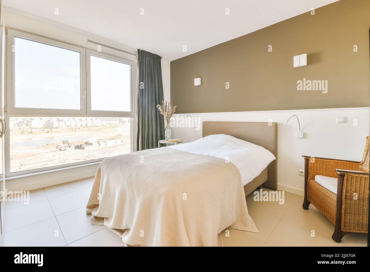 Comfortable bed next to a bright window with curtains Stock Photo - Alamy