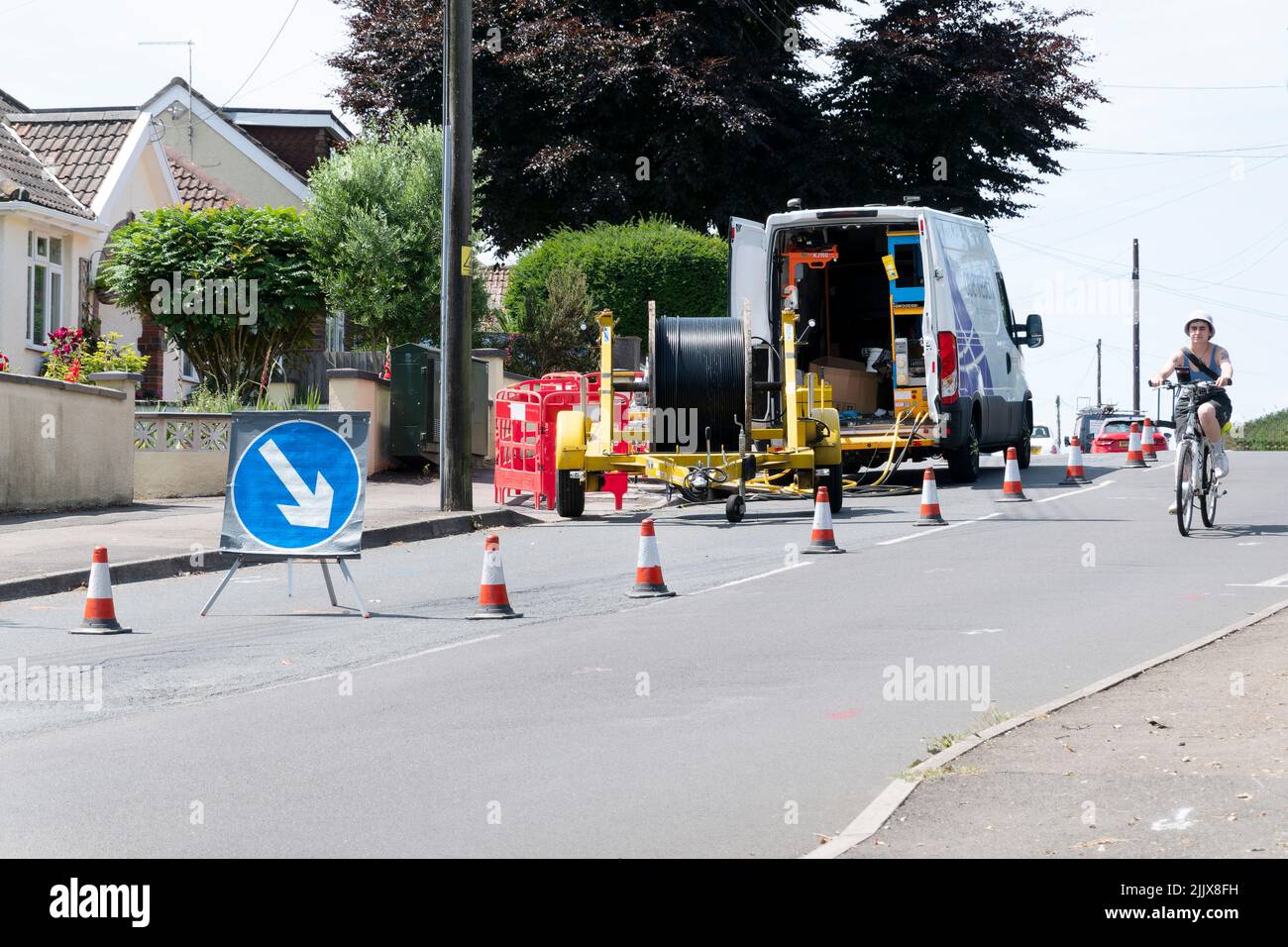 A BT Openreach team work on upgrading residents to high speed broadband by replacing existing cables having sectioned off a road to traffic Stock Photo