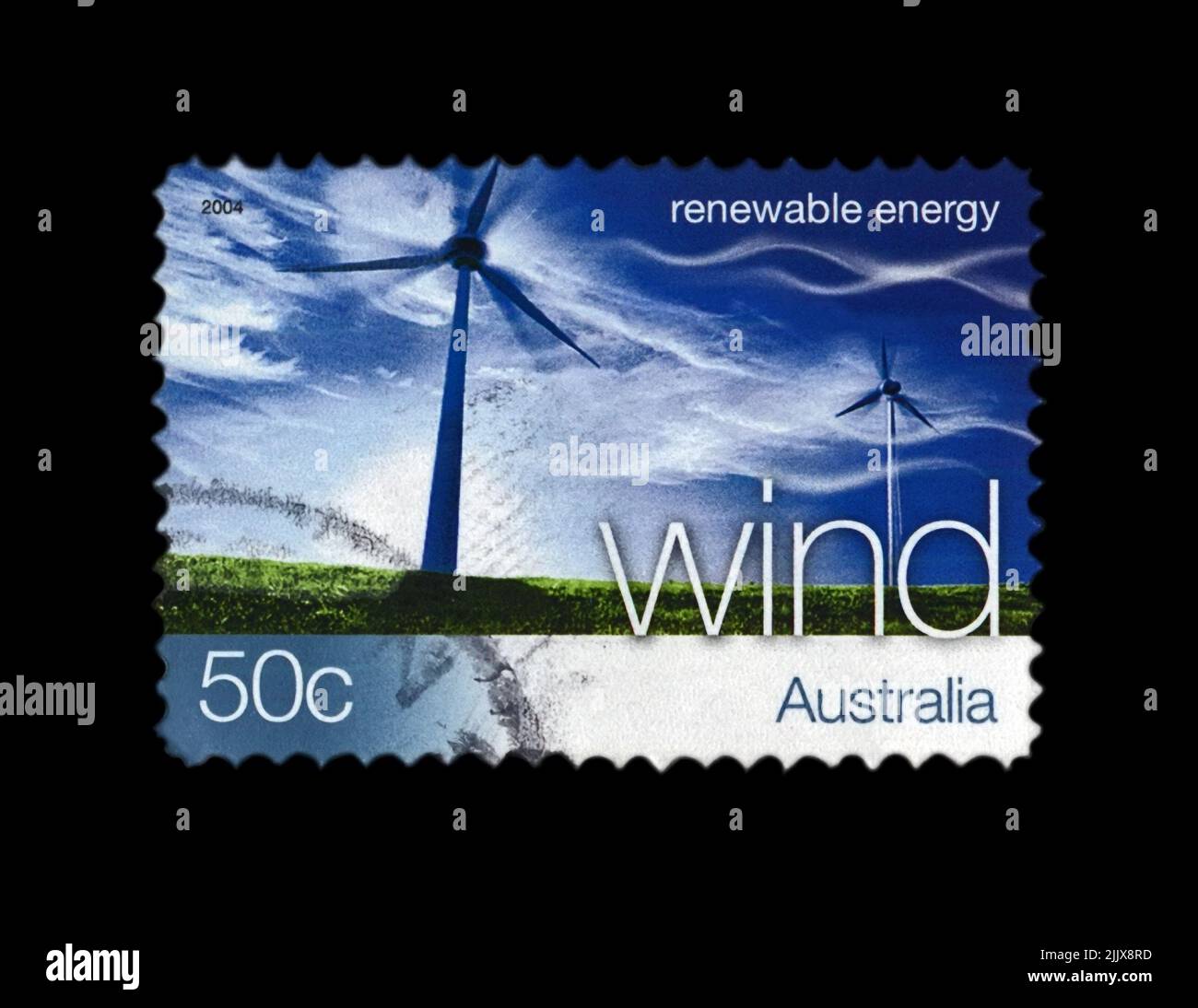 wind station on blue sky with clouds, wind renewable energy, circa 2004. canceled postal stamp printed in Australia isolated on black background. Stock Photo