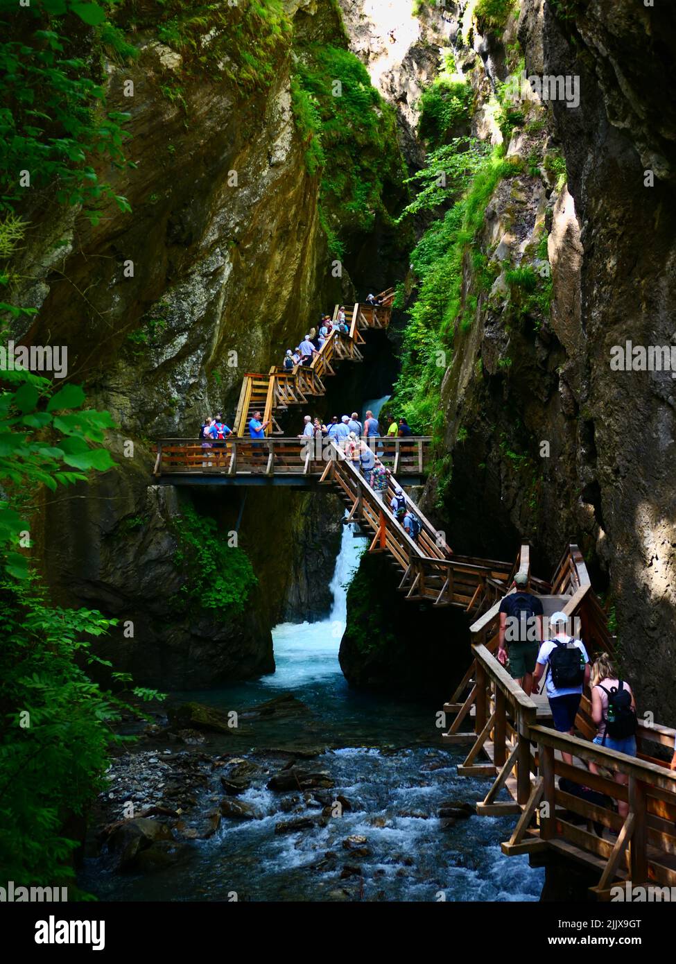 Tourists walking visiting on wooden stairway steps, Sigmund Thun Klamm Gorge, Austria Stock Photo