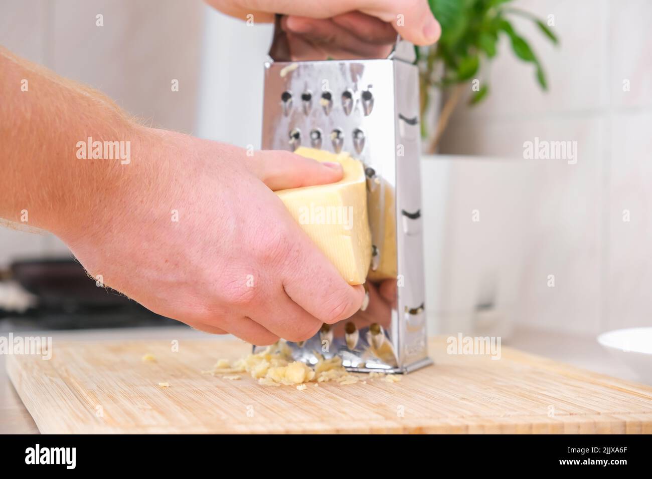 Hands using a cheese grater Stock Photo - Alamy