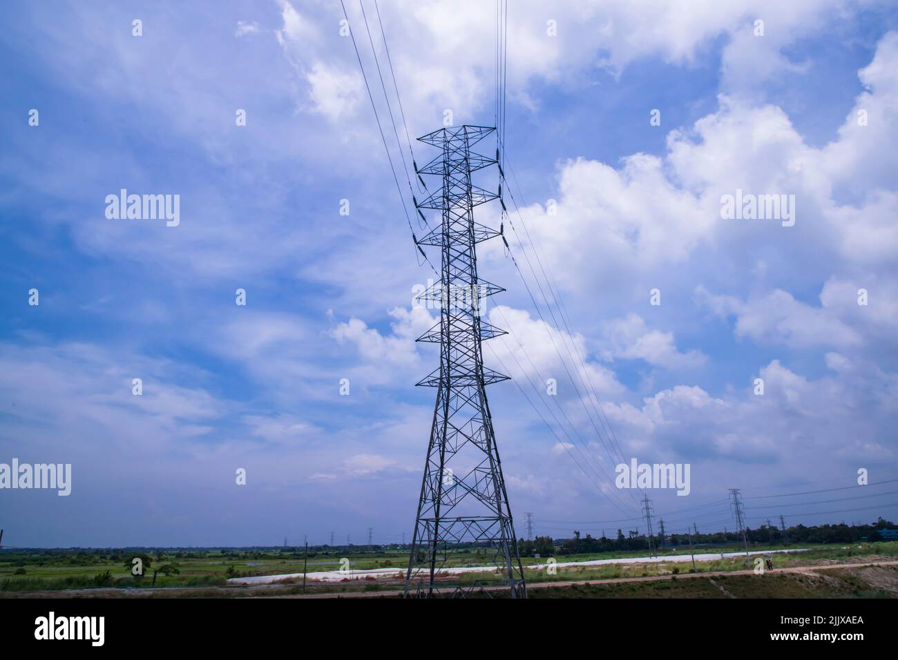 High voltage Electricity pylon under the cloudy blue sky Stock Photo ...