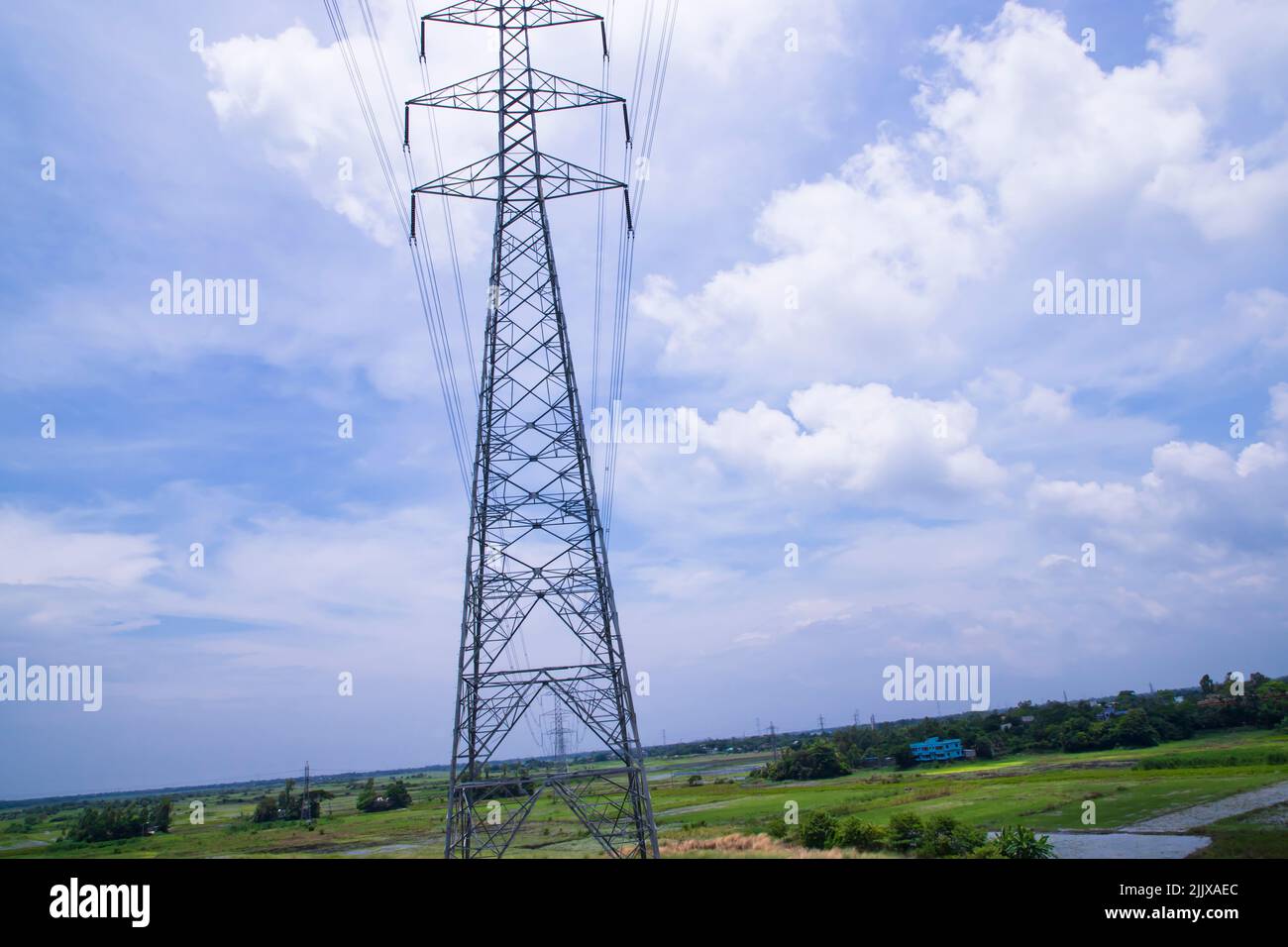 High voltage Electricity pylon under the cloudy blue sky Stock Photo ...
