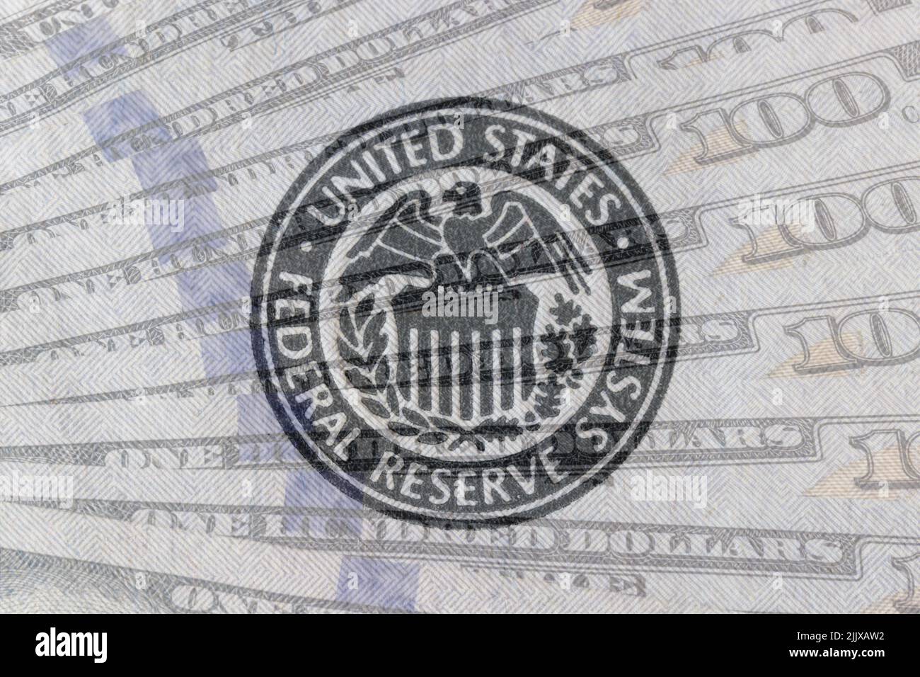 Federal Reserve System seal overlay on a bed of hundred dollar bills. The Fed's responsibilities include setting interest rates and regulating financi Stock Photo