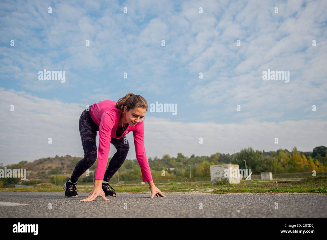 Attractive and fit girl is concetrating and doing a starting position for running in the morning Stock Photo