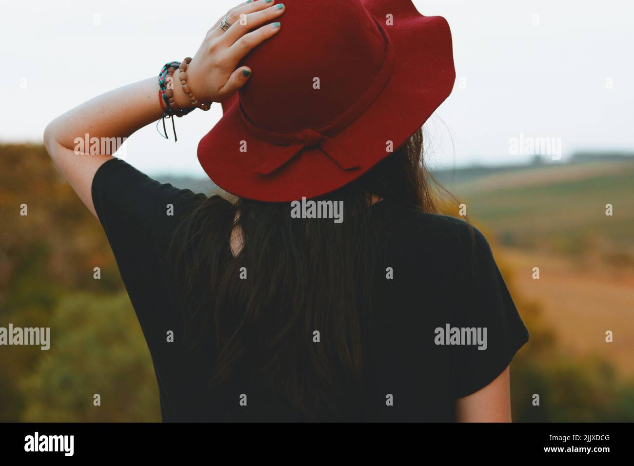 woman from the back holding a hat Stock Photo