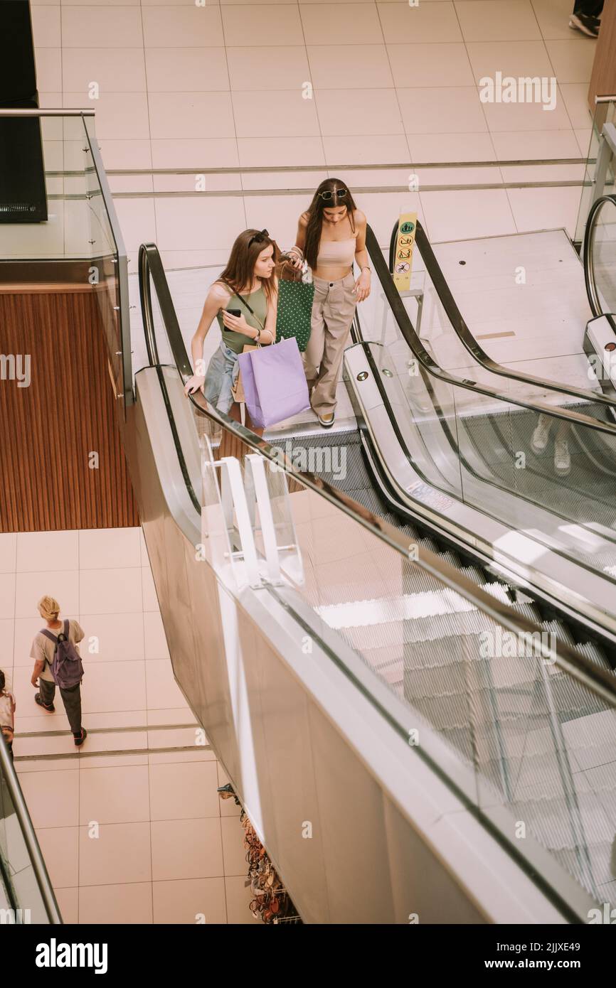 Two pretty girls on the escalator at the mall Stock Photo - Alamy
