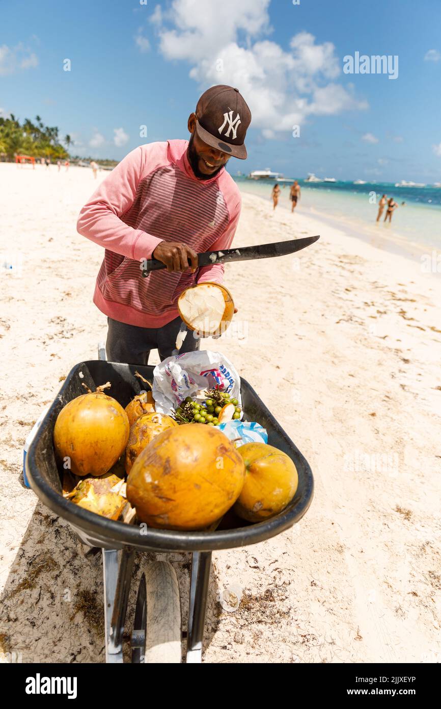 07.24.2022. Dominican Republic, Punta Cana Bavaro province of La Altagracia. Coconut seller on the beach. Stock Photo