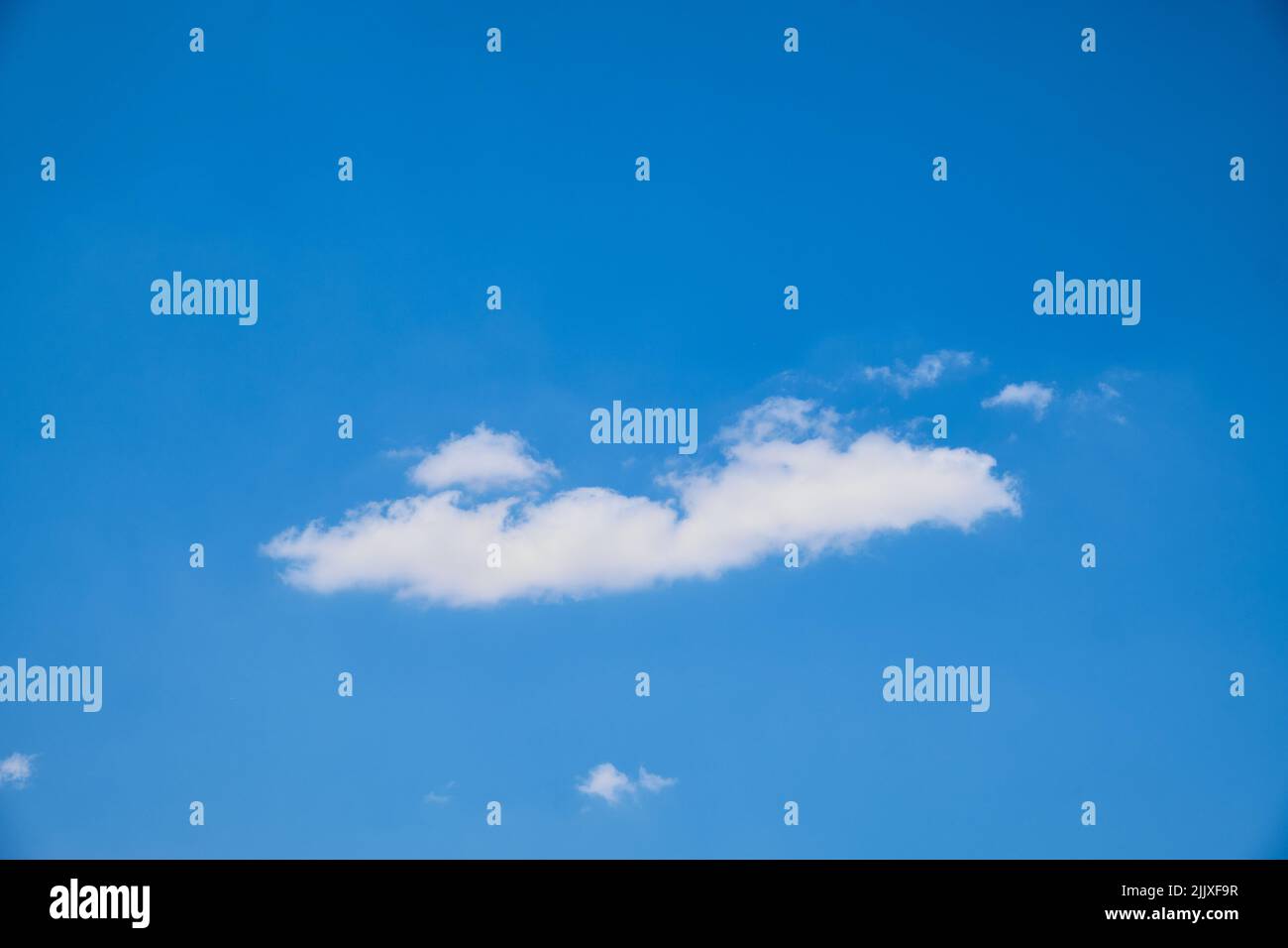 Cumulus clouds against bright blue sky Stock Photo