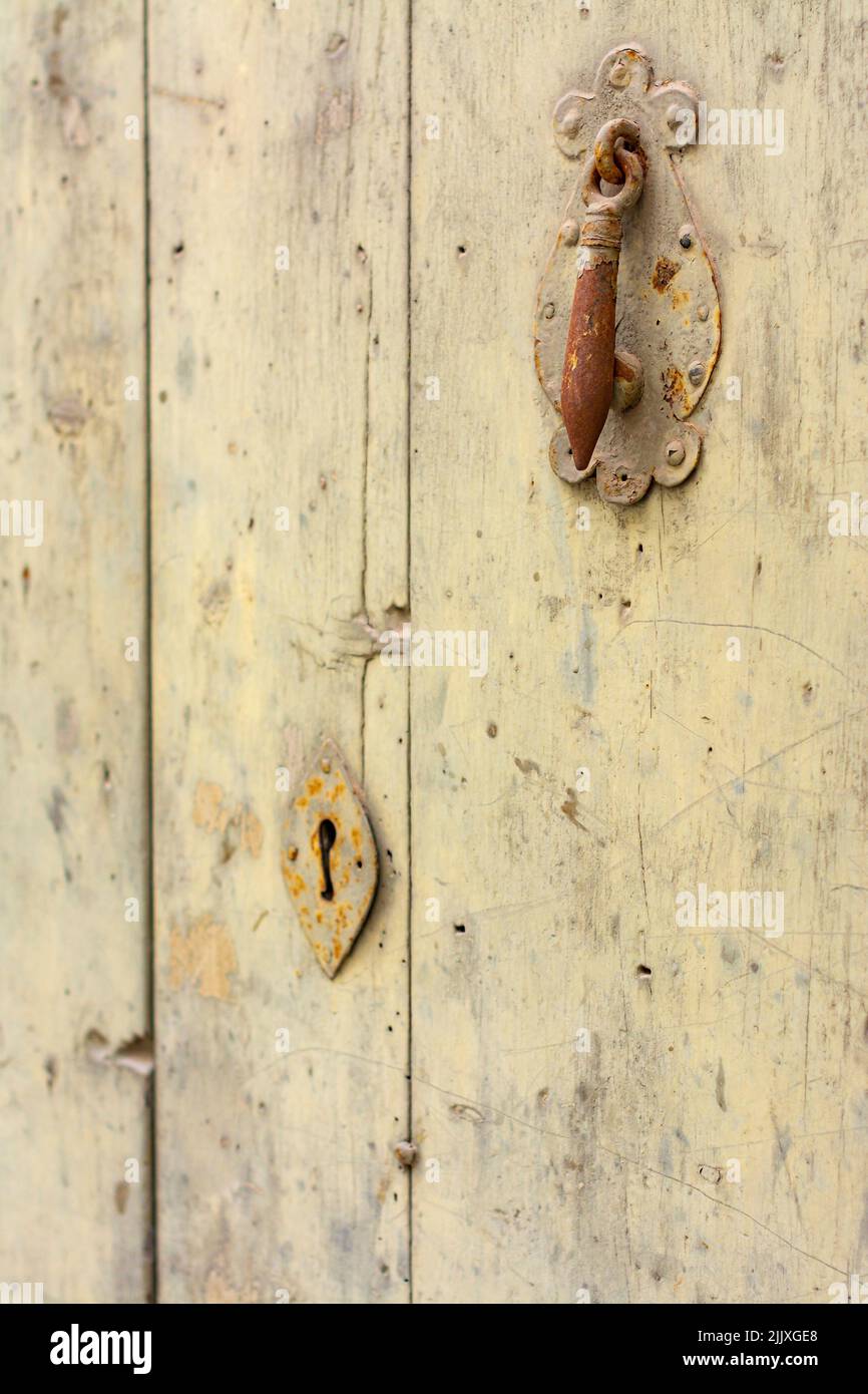 Old rusty knocker and lock, on an old, yellowed wooden door, with copy space Stock Photo