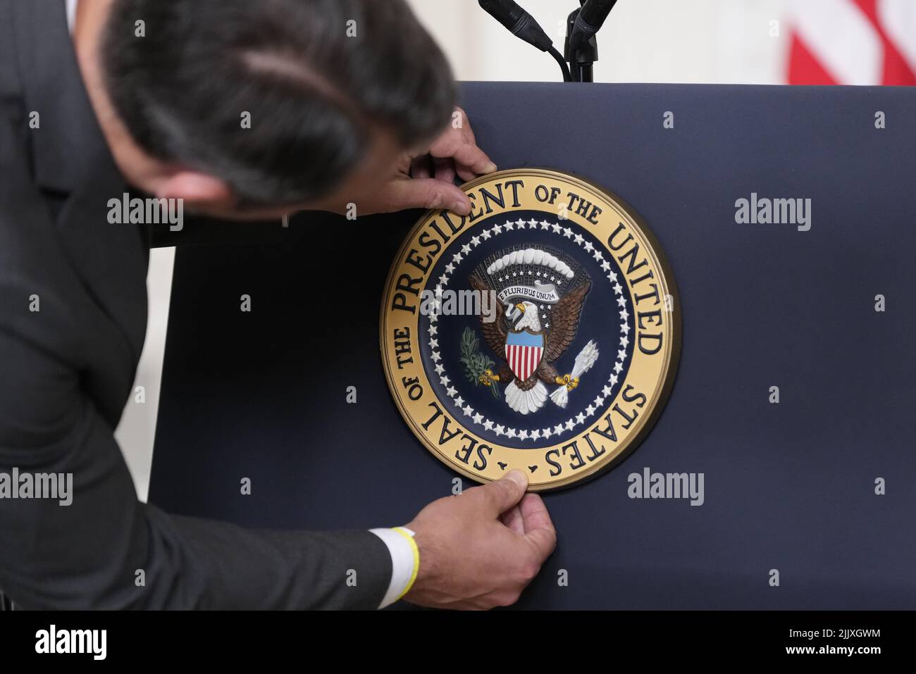 An aide adjusts the seal on the podium prior to United States President Joe Biden delivers remarks on the Inflation Reduction Act of 2022 in the State Dining Room of the White House in Washington, DC on Thursday, July 28, 2022. This legislation, designed fight inflation and lower costs for American families was announced July 27, 2022 by United States Senate Majority Leader Chuck Schumer (Democrat of New York) and US Senator Joe Manchin III (Democrat of West Virginia). Credit: Chris Kleponis/Pool via CNP /MediaPunch Stock Photo