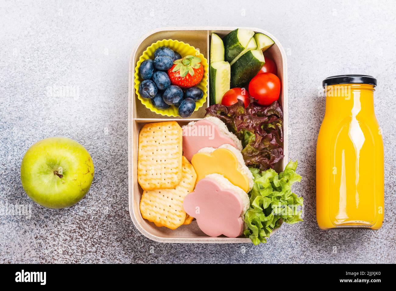 Healthy school lunch box. Flower sandwiches, berries and orange juice