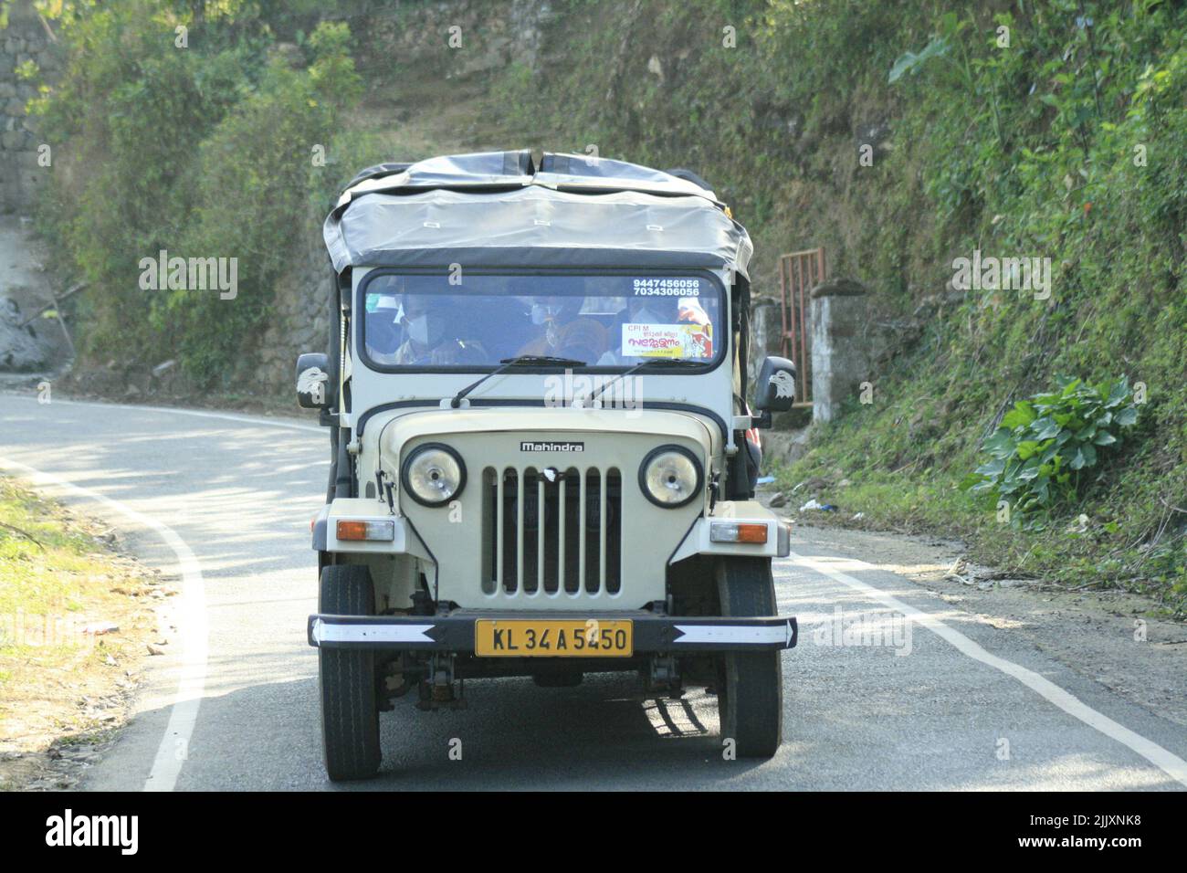 A Mahindra jeep cruising on a mountain road on a sunny day Stock Photo