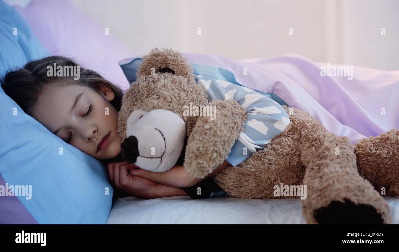 Child in pajama sleeping with soft toy at home Stock Photo Alamy