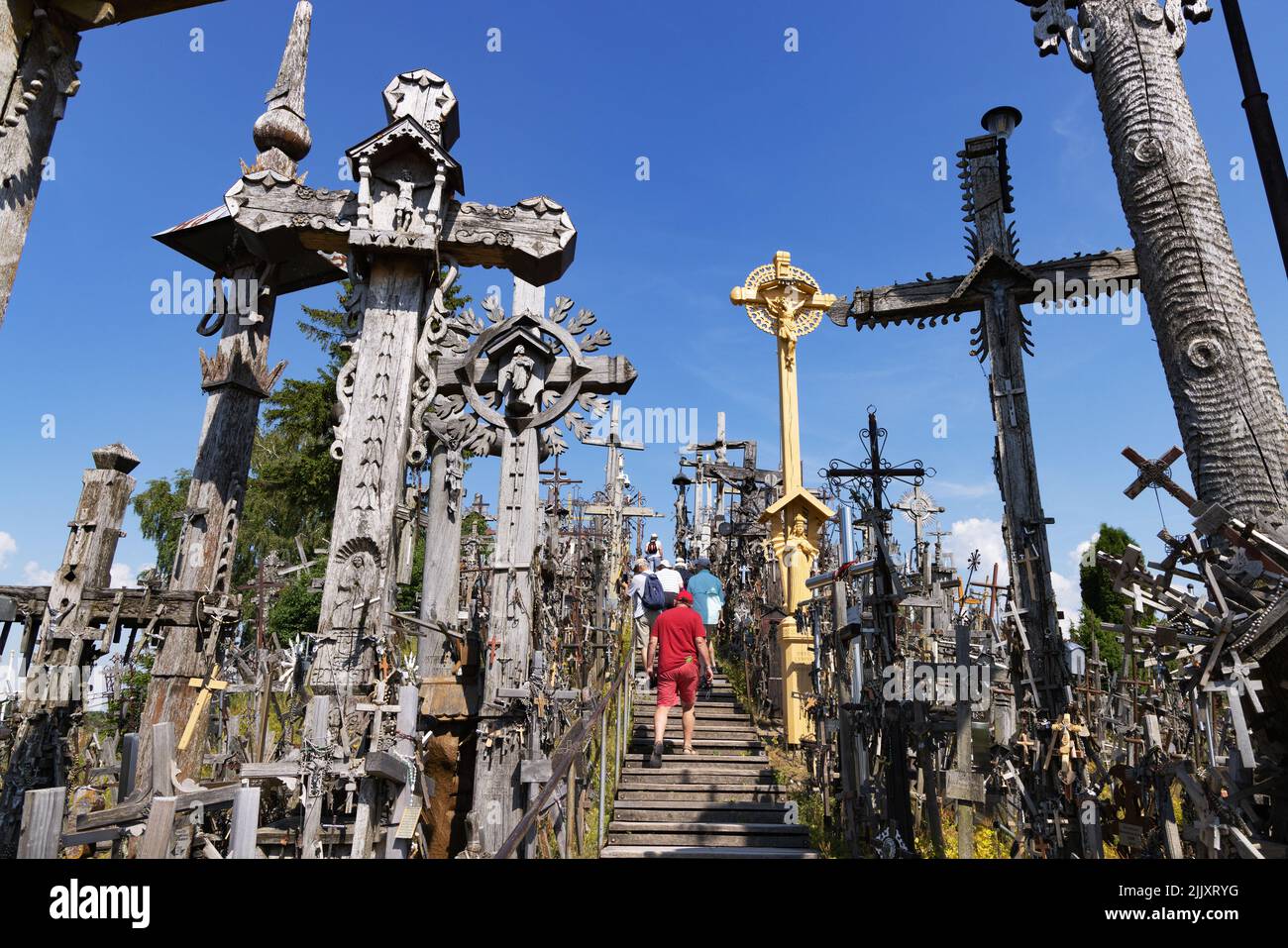 Lithuania tourists; people visiting the Hill of Crosses, a site of christian religious pilgrimage with many crosses and statues, Lithuania Europe Stock Photo