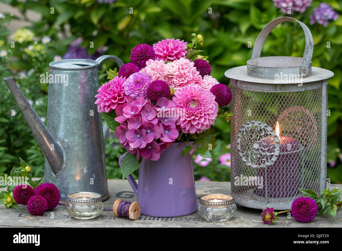 romantic arrangement with bouquet of pink and purple flowers and vintage lantern Stock Photo