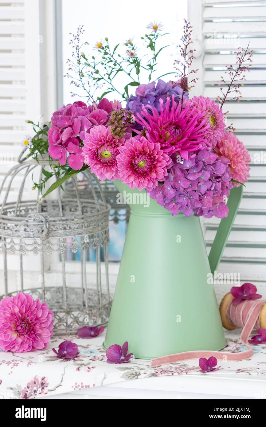bouquet of pink dahlia and hydrangea flowers in vintage jug Stock Photo