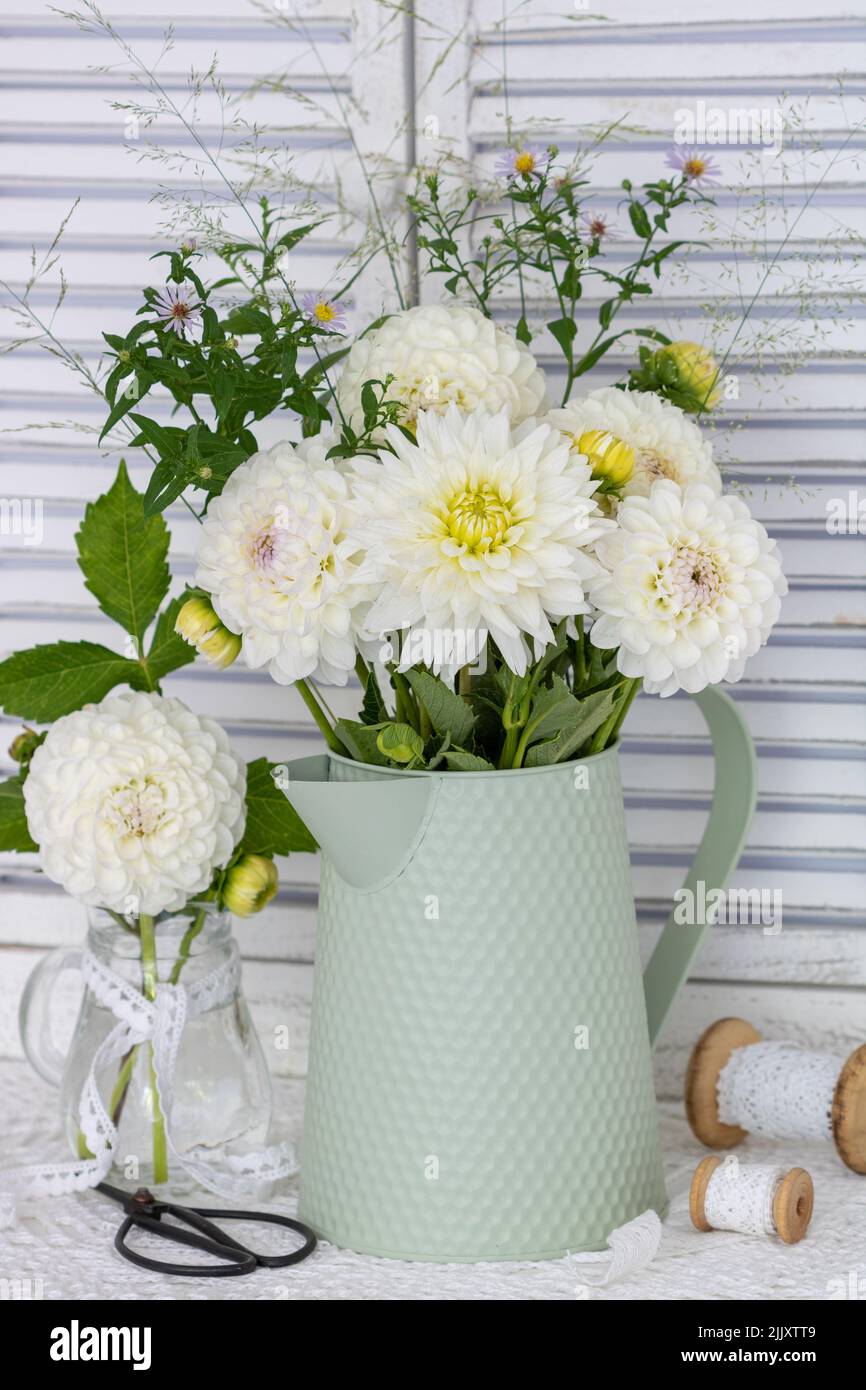 arrangement with bouquet of white dahlia flowers in vintage vase Stock Photo