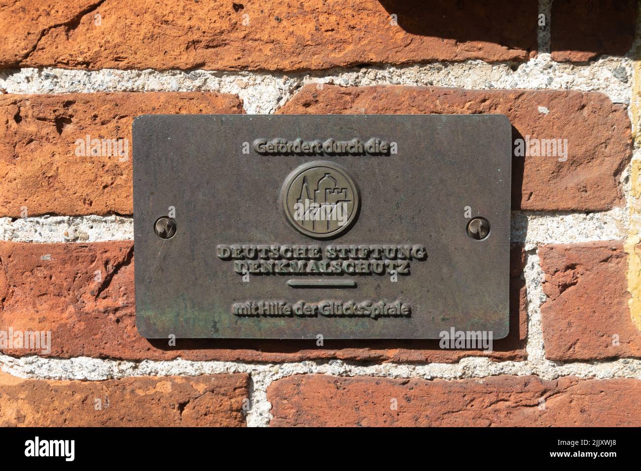 Plaque at the entrance of the chief's castle Steinhaus Bunderhee in Bunde, East Frisia, Lower Saxony, Germany. Sponsored by the German Foundation for Stock Photo