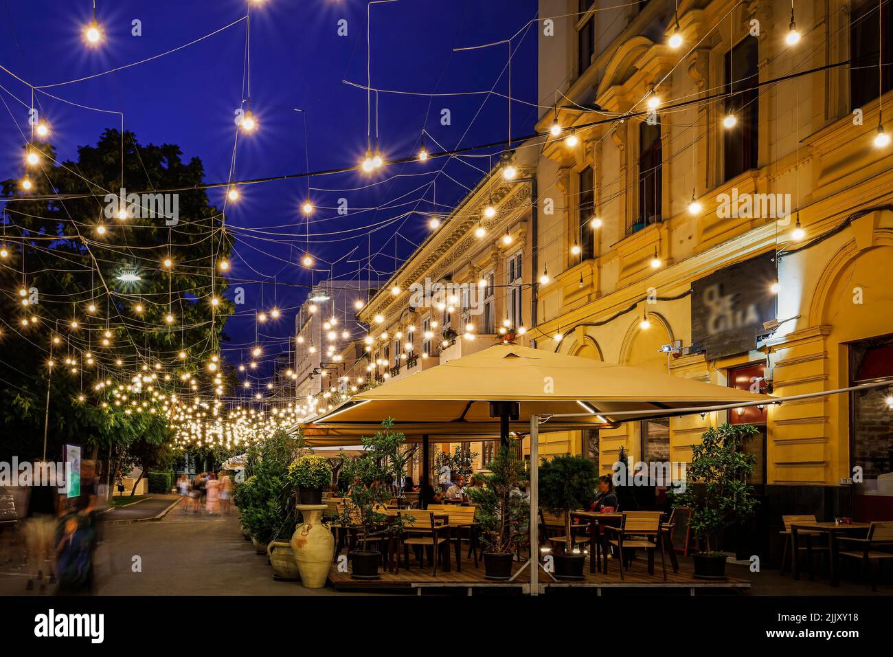 Pedestrian street with restaurants and terraces, decorated with hundreds of light bulbs. Photo taken on 17th July 2022 in Arad, Arad County, Romania. Stock Photo