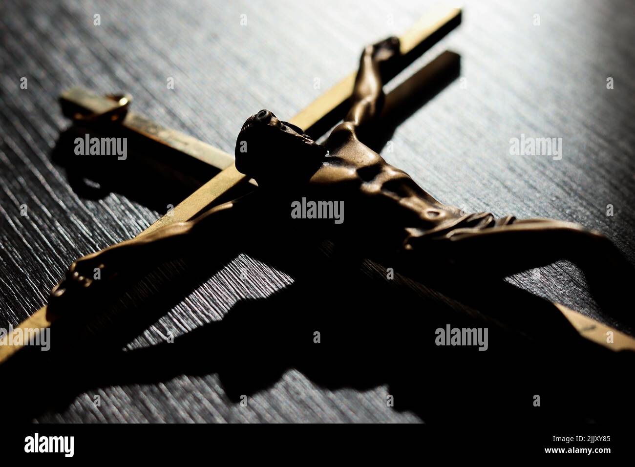 A closeup of Jesus on the cross figure on wooden table Stock Photo