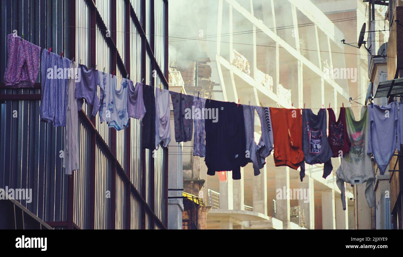 A laundry line with hanging drying clothes outside a building Stock