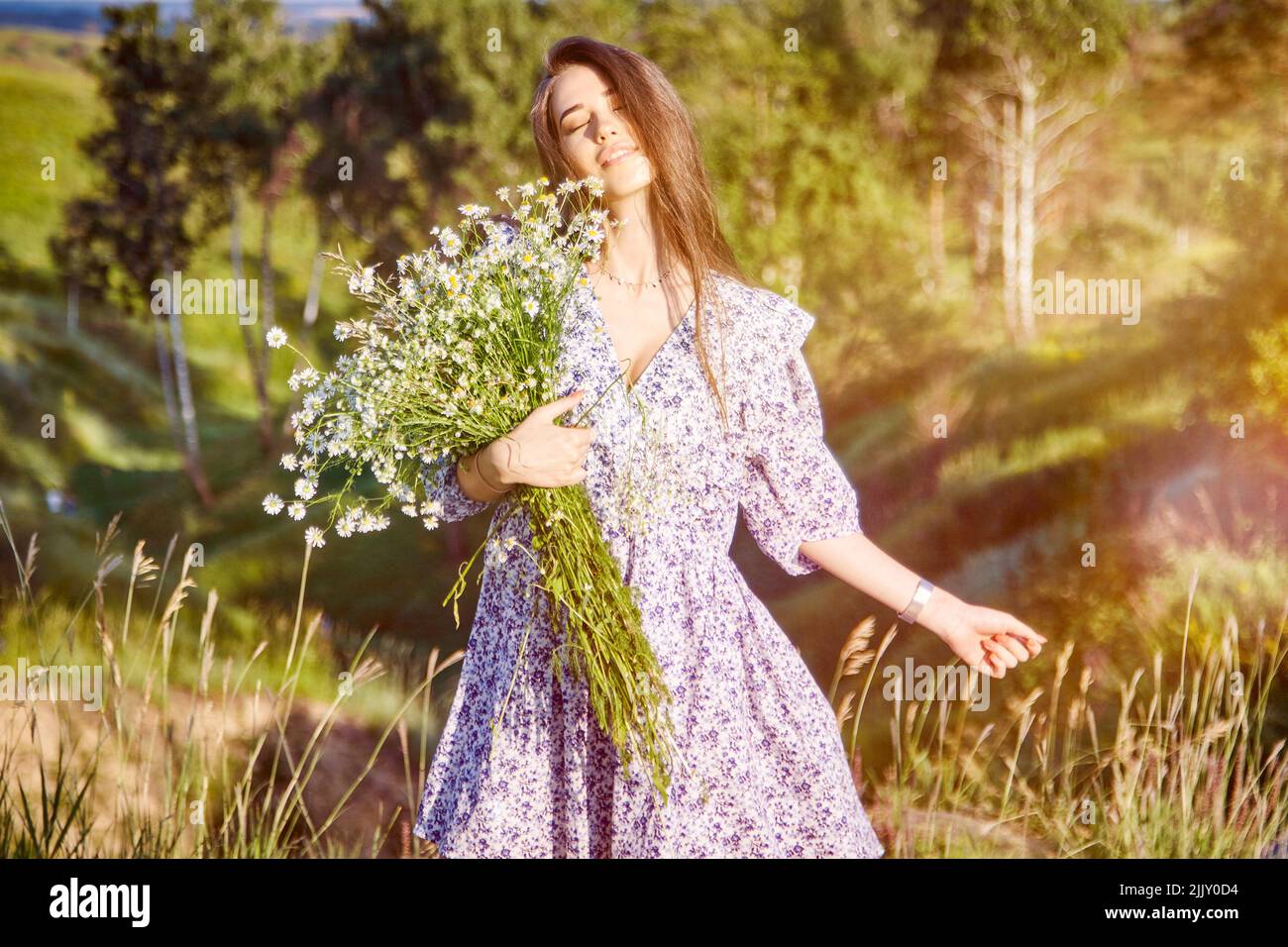 young beautiful girl with a bouquet of flowers in nature Stock Photo ...